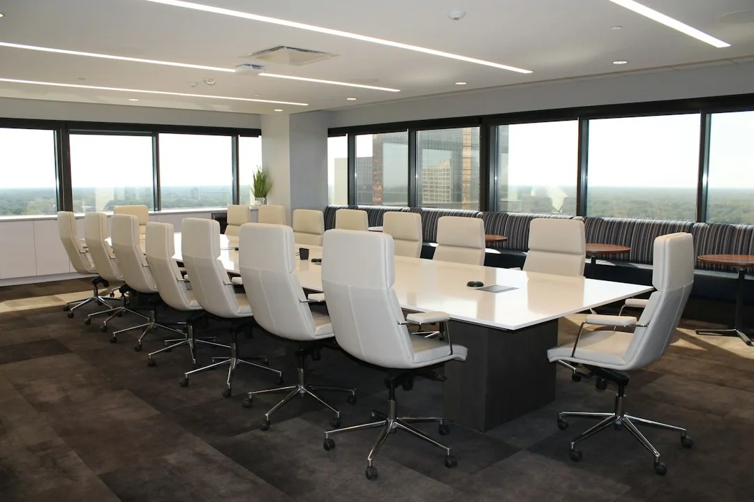 A contemporary meeting room with a long table and natural light